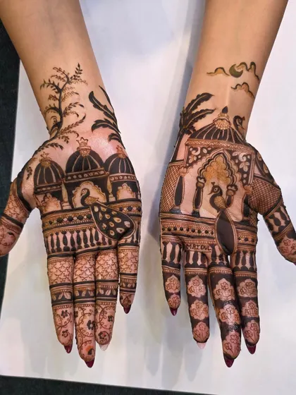 A clear, well-lit shot of a modern scenic mehandi design. The bold lines and artistic composition with peacocks and domes make this a very popular style.
