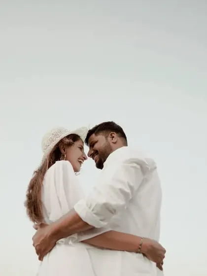 A simple, clean, and intimate portrait against the sky. The focus is entirely on their connection and happiness.