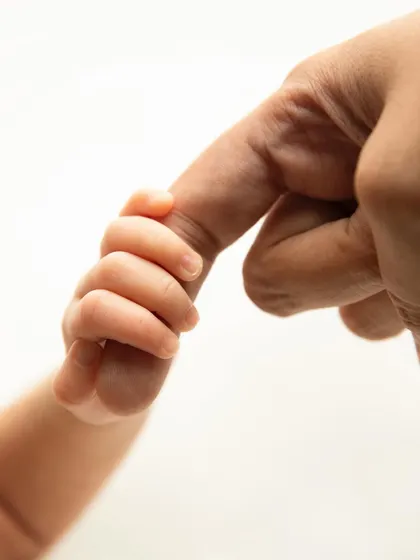 Sometimes the most powerful portraits are in the smallest details. This tiny hand holding a parent's finger tells a story of connection, trust, and unconditional love that you will cherish forever.