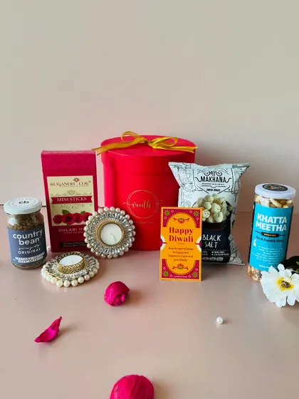 The contents of the round red box displayed, showing the variety of treats you can include even in a budget-friendly hamper.