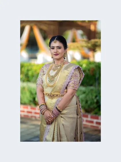 A portrait of the bride in a beautiful cream and gold saree, looking elegant and serene.