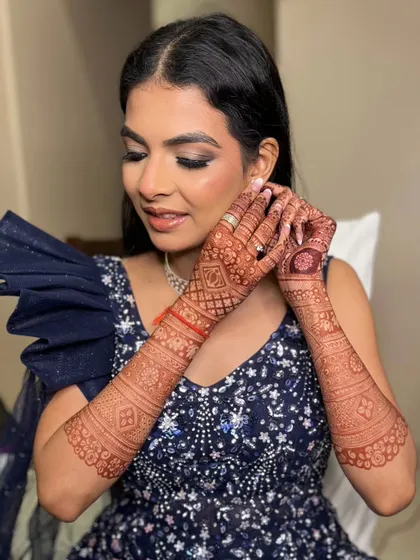 The intricate henna design is beautifully complemented by the glamorous makeup.
