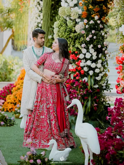 A romantic portrait of the couple surrounded by the vibrant floral arches I designed for their engagement. The decor included whimsical swan props to complete the garden party theme.