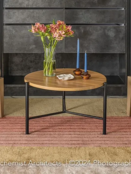 A close-up of the lounge styling, showing a simple wooden coffee table adorned with fresh flowers and candles. These small details help complete the look and feel of a space.