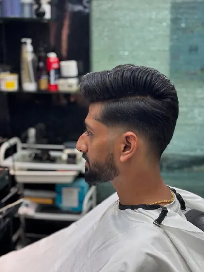 A side profile of a classic pompadour. Notice the clean side part and the smooth, flowing shape of the hair.