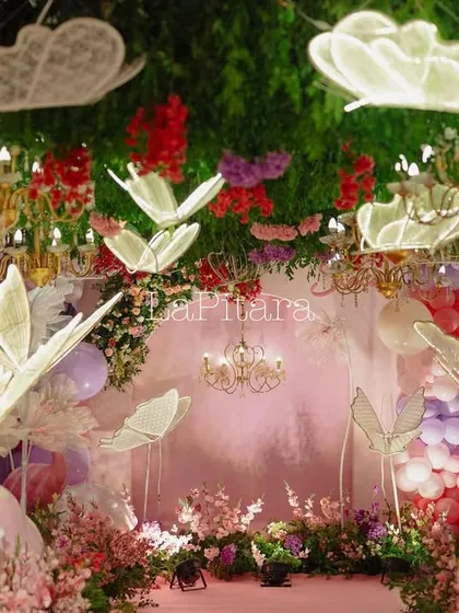 A close-up of the glowing butterfly entrance, showing the intricate lace-like details on the butterfly wings and the lush greenery on the ceiling, creating a sense of wonder.