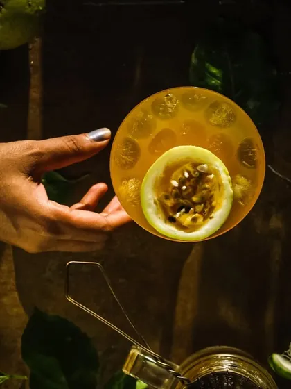 A top-down shot of the passion fruit cocktail, highlighting the garnish and rich color.