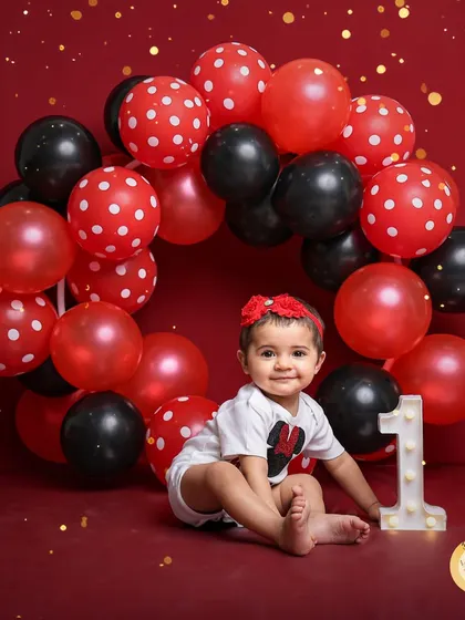 This little girl looks adorable in her Minnie Mouse inspired outfit, surrounded by a red, black, and polka-dot balloon arrangement. We can customize colors and themes to match your party.