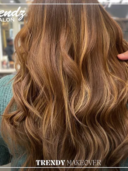 A radiant balayage with warm, honey-blonde highlights. The soft waves perfectly showcase the seamless blend of colors.