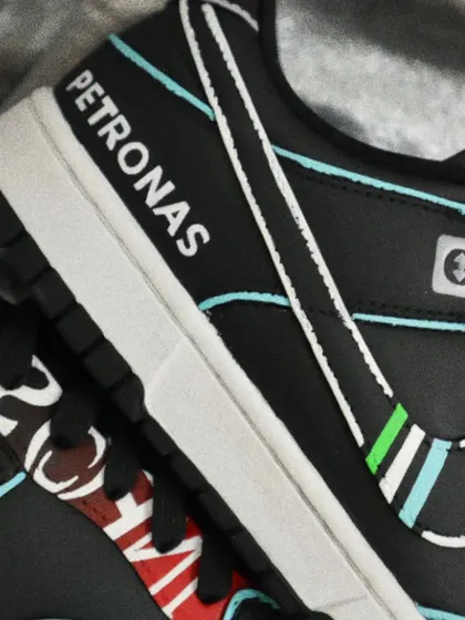 A close-up of the Mercedes F1-themed Dunks, showing the hand-painted Petronas logo. Precision is key for these designs to ensure every detail is crisp and authentic.