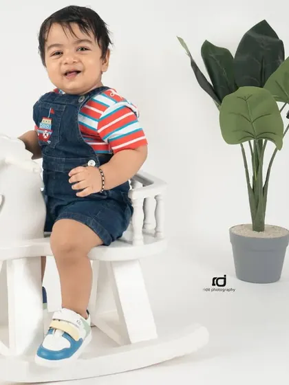 A big smile from the birthday boy. This simple and happy shot on a rocking horse captures the cheerful spirit of a one-year-old.