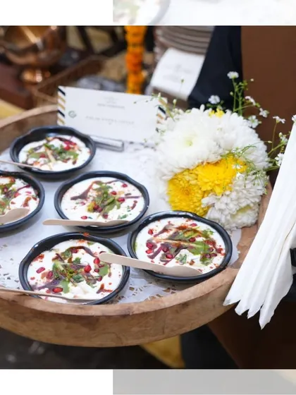 Dahi Bhalla served elegantly in individual black bowls on a wooden tray. This presentation makes it easy for guests to enjoy this refreshing and tangy chaat.