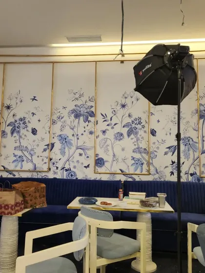 Another view of the blue and white botanical wall painting, showing how it complements the cafe's seating area. This style is perfect for creating a calm and beautiful ambiance.
