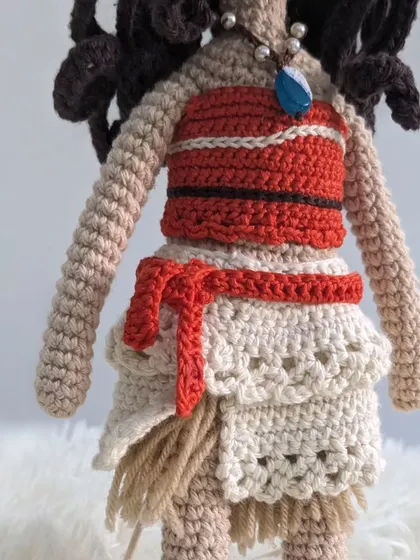 A detailed shot of the Moana doll's outfit, including her layered skirt and red sash.