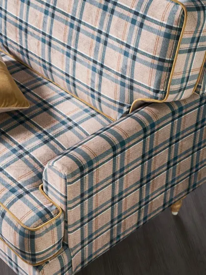 A detailed close-up of the plaid upholstery, showing the texture of the weave and the clean lines of the piping. This shot is essential for communicating fabric quality online.