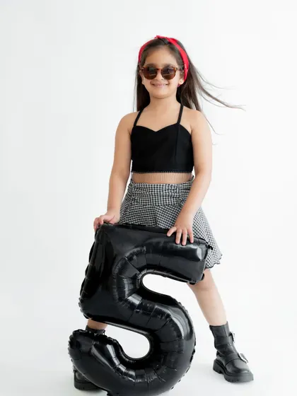 Five and fabulous! This stylish fifth birthday shoot with a simple white background and a bold number balloon lets your child's personality shine.