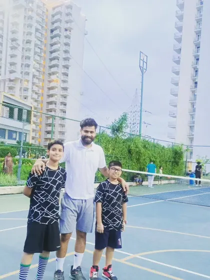 More teammates and friends, posing for a photo on the court against the Gurugram skyline.