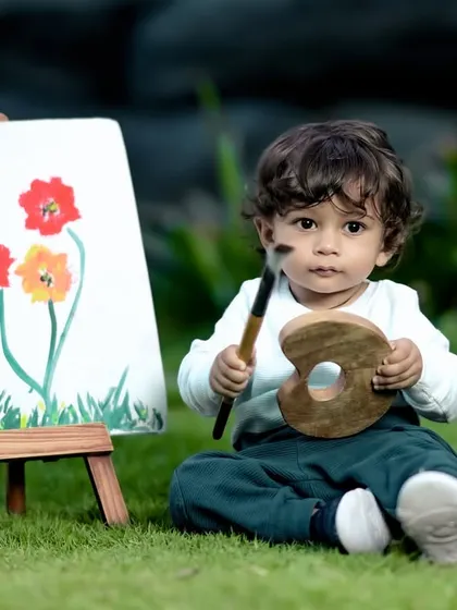 A close-up of our little Picasso, holding his paintbrush and palette with a serious, artistic expression.