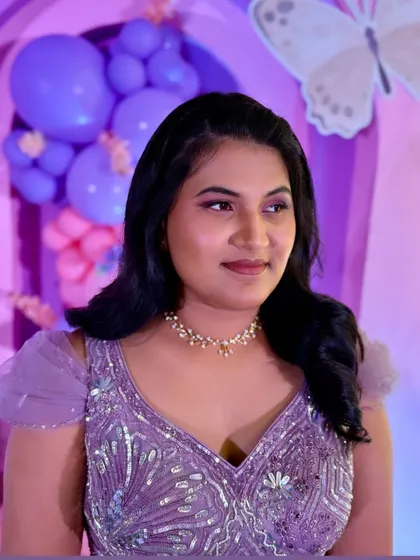 A side profile of Mrudulla, showing her soft waves and minimalist makeup that complemented her lavender gown.