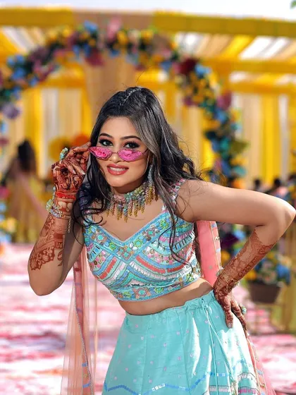 Fun and fashion at a Haldi event. Our client pairs her custom colorful jewelry set with playful pink sunglasses, showing how accessories can express your personality.