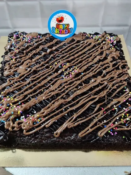 My brownies can also be turned into a celebration cake. This is a large, fudgy brownie slab decorated with chocolate drizzle, rainbow sprinkles, and a "Happy Birthday" topper.