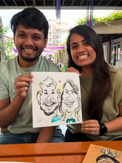 A happy couple from the ISB alumni meet with their personalized caricature.