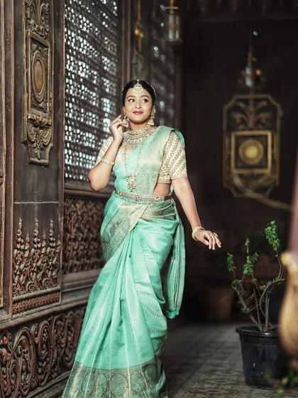 This pastel mint green Kanchi silk saree offers a soft and sophisticated look, perfect for a daytime wedding or reception.