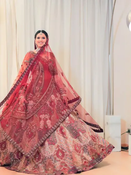 A joyful, twirling shot of the bride, showing the beautiful movement and detail of her wedding lehenga. Her happiness is infectious in this dynamic portrait.