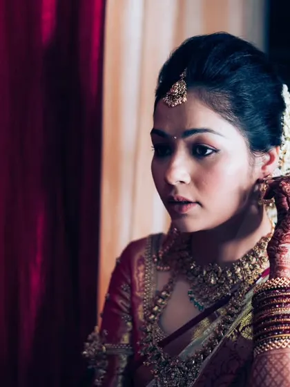 The final touches being made to the bride's hair and earrings, a moment of focus and anticipation before the ceremony.