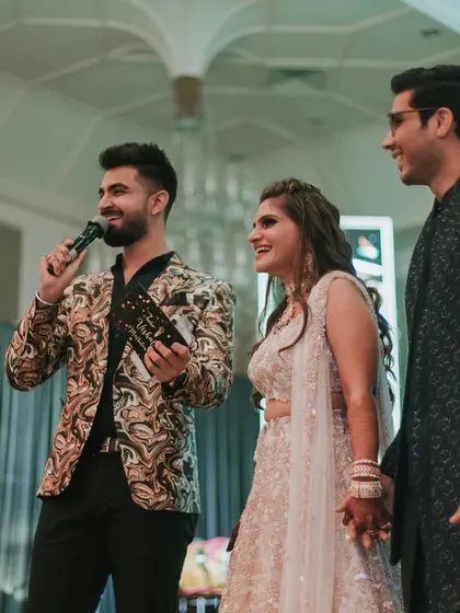 The anchor engages with the happy couple on stage, keeping the energy high and the event flowing smoothly.