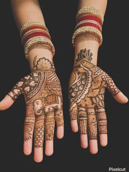 A beautiful example of asymmetrical bridal mehndi. One hand features a royal elephant, while the other has a detailed peacock, both tied together with similar patterns and a lotus cuff.