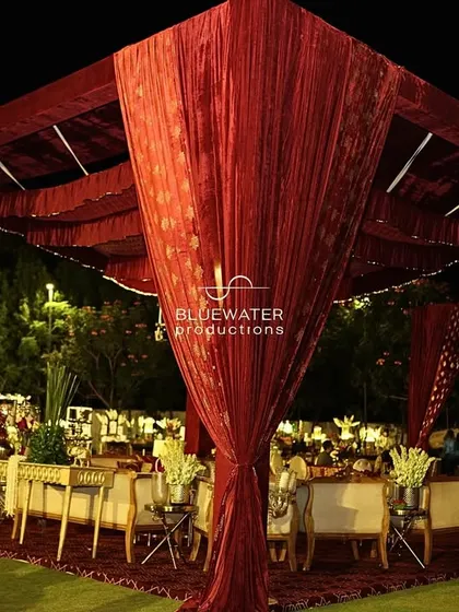 A large draped cabana houses one of the many lounge areas at the grand wedding reception.