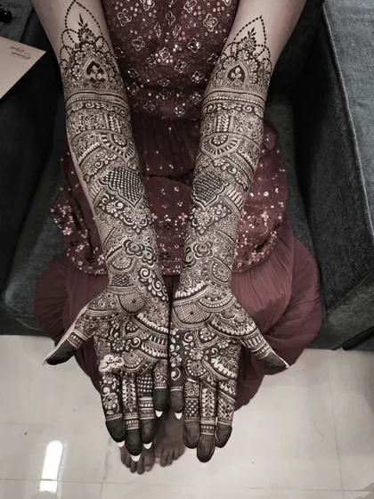 This black and white shot emphasizes the texture and complexity of a full bridal design, showing the depth and layers of the henna pattern.