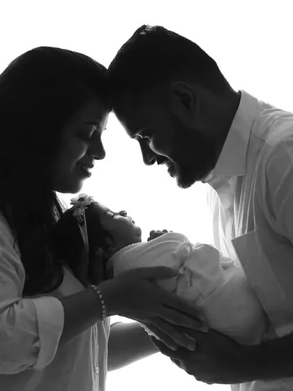 A new family of three, captured in a loving high-key silhouette. This technique creates a timeless and artistic feel, focusing purely on their connection.