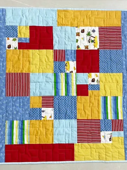 A full view of the abstract block baby quilt, perfect for stimulating a baby's senses.