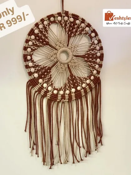 A beautiful dreamcatcher-style wall hanging in brown and beige. The floral pattern and fringe make it a stunning centerpiece.