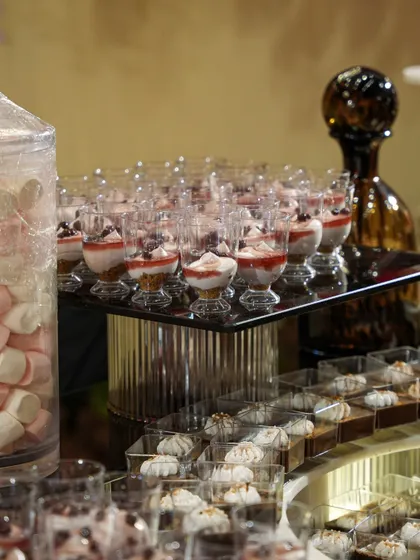 A dessert station featuring layered parfaits in glass cups and delicate meringue kisses. The display is elegant and abundant, offering guests a variety of light and airy sweet options.