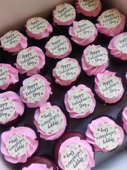 Celebrating Valentine's Day at work? We create custom cupcakes for corporate orders, like this large batch of red velvet cupcakes with "Happy Valentine's Day" toppers.