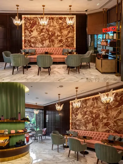 At the Fabelle chocolate boutique in ITC Maurya, we used a custom cocoa bean mural as a stunning backdrop. The combination of a pink tufted sofa, sage green chairs, and warm lighting creates a rich, inviting pantry section that tells the brand's story.