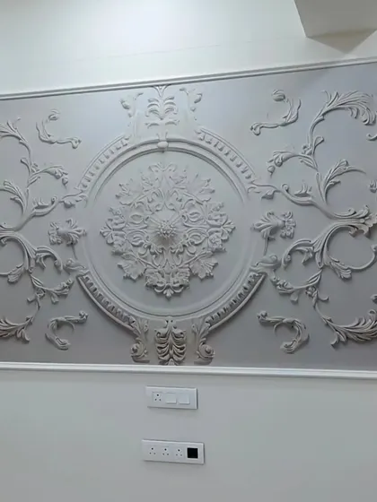 A custom 3D wallpaper that mimics ornate classical molding. Installed within a frame, it gives the impression of a large, plaster art piece in this Andheri West home.