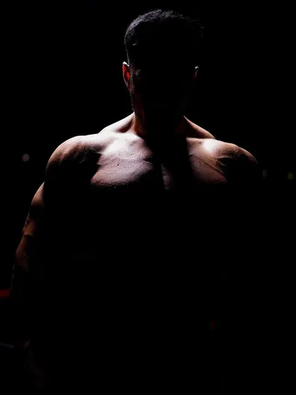 The silhouette of a well-built physique. This dramatic shot captures the result of dedication to strength training and bodybuilding at our academy.