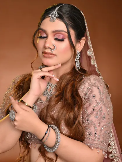 This student portfolio shot showcases a soft pink cut crease, a very popular and modern bridal choice. The long, wavy hair complements the romantic feel of the makeup.