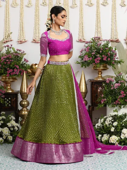 Bandhani brilliance meets bridal glam in this olive green lehenga with a magenta blouse and a silver zari border.