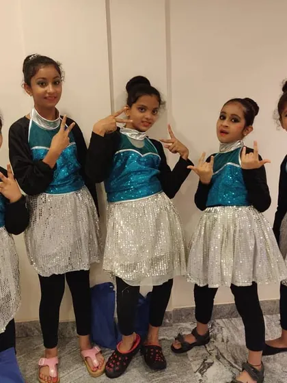These girls are ready to rock the stage for a Durga Pooja celebration. Their coordinated costumes and confident poses show they are ready for a great performance.