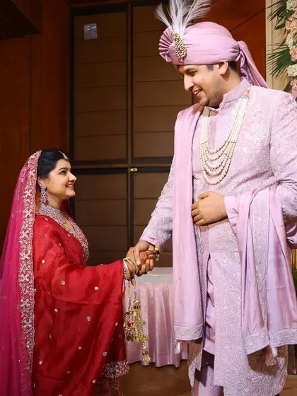 A candid moment of the couple holding hands and sharing a smile during their wedding reception.
