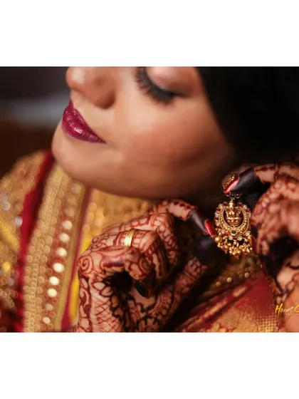 A detailed shot of the bride putting on her traditional earring. Capturing these final touches is part of the "getting ready" story.