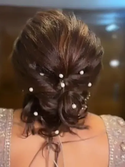 A textured bun with pearl accents, captured in the process of being finalized.
