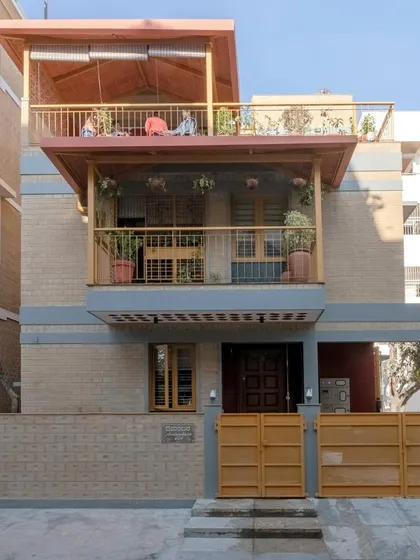 The front facade of Audumbara, showcasing the use of CSEB and the prominent balconies that define its character.
