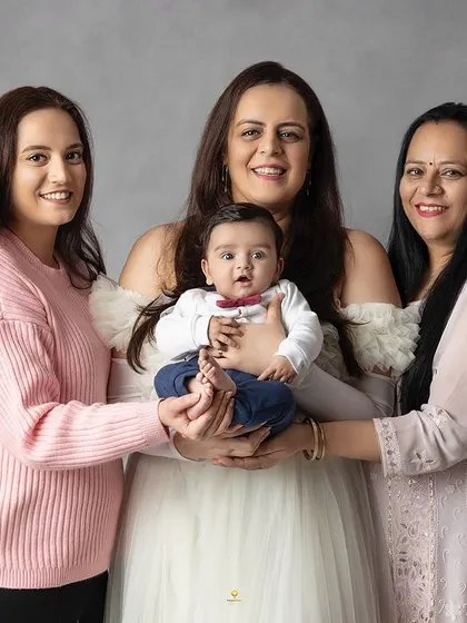 The women of the family gathered around the new baby. This portrait highlights the strong bonds between a mother, her sister, and their own mother, all sharing in the joy of a new life.