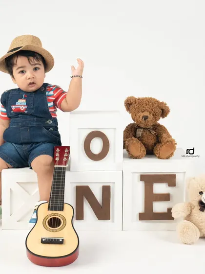 Waving hello to being one year old. This is a perfect shot to capture a child's personality at this fun age.